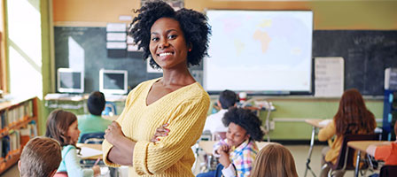 a teacher smiling confidently with kids in the background