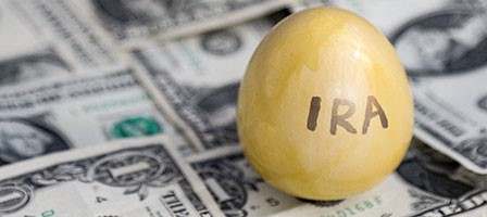 a golden egg with ira written on it on top of a pile of money