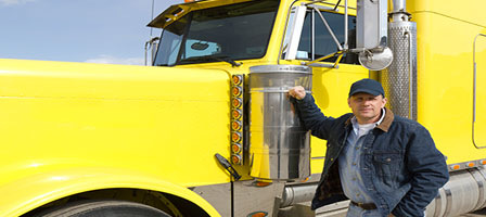 a man standing next to a yellow semi truck