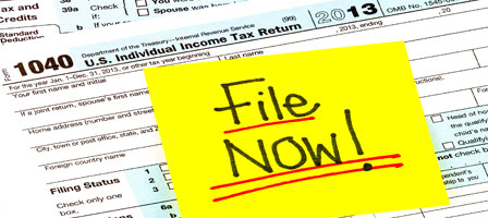 tax paperwork with a sticky note that says file now