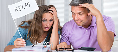 a man and woman looking at paperwork and the woman holding a white flag that says help