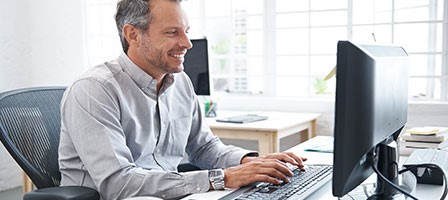 a man sitting at a desk working on his desktop