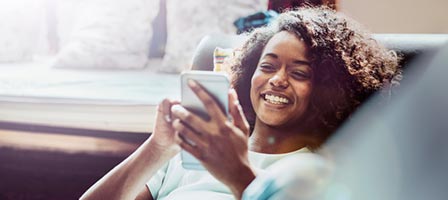 a woman laying on a couch looking at her phone