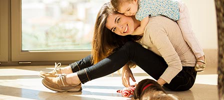 a woman sitting smiling with a toddler on her back