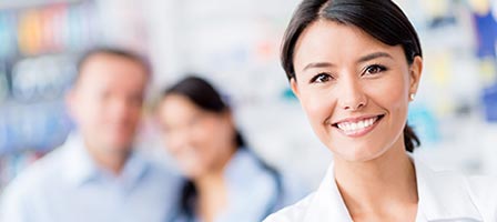 a woman smiling confidently with two people behind her