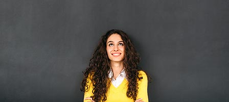 a woman looking up standing in front of a chalk board