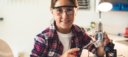 a girl working on a robotic arm