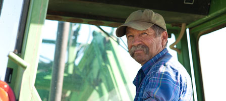 a man sitting in farm equipment