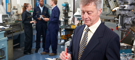 a man writing on a clipboard with others talking behind him