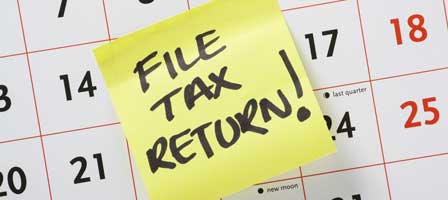 a sticky note on a calender that says file tax return