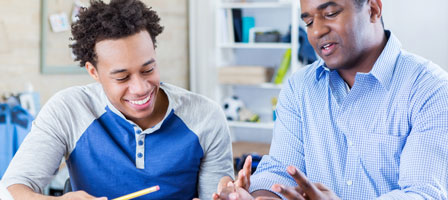 a man and teenage boy sitting talking