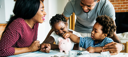 a family putting money into a piggy bank