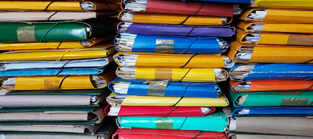 a lot of folders filled with documents stacked 