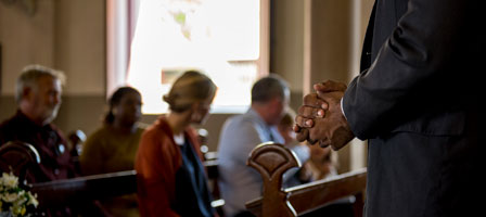 a man in front of people in church pews