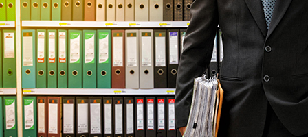 a man holding files while in a file room