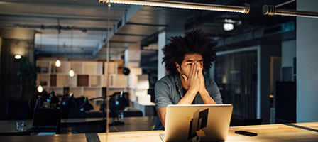 a man sitting at a desk looking stressed 